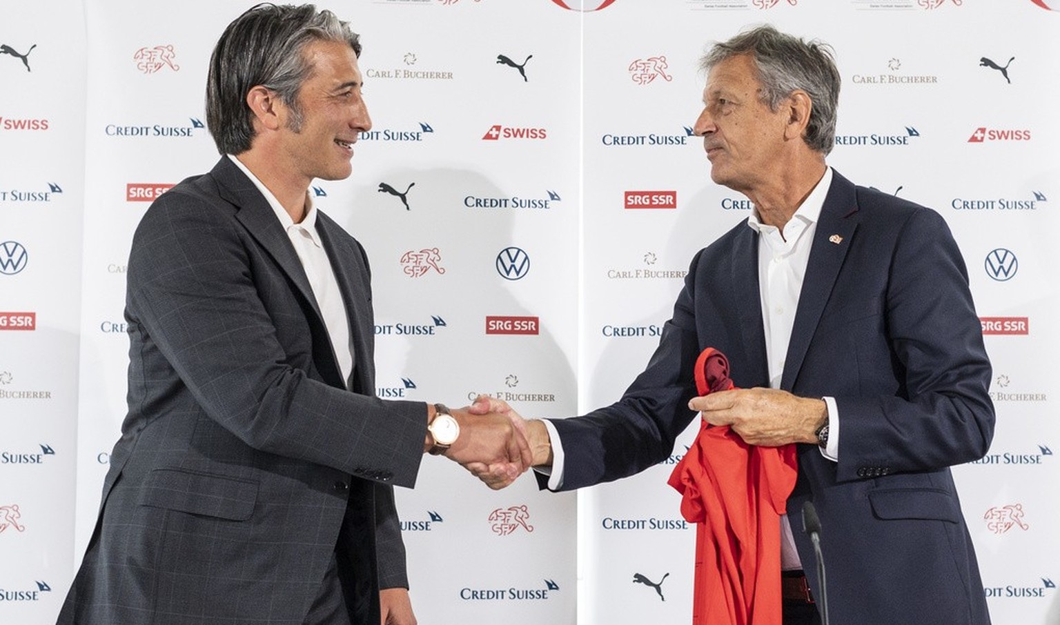 Swiss soccer coach Murat Yakin, left, shakes hands wth Dominique Blanc, president of the Swiss football federation SFV, at a press conference where he is presented as the new coach of the team in Muri ...