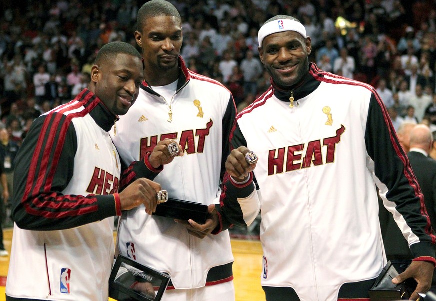 FILE - In this Oct. 30, 2012 file photo, Miami Heat&#039;s Dwyane Wade, left, Chris Bosh, center, and LeBron James pose with their championship rings during a ceremony before an NBA basketball game ag ...