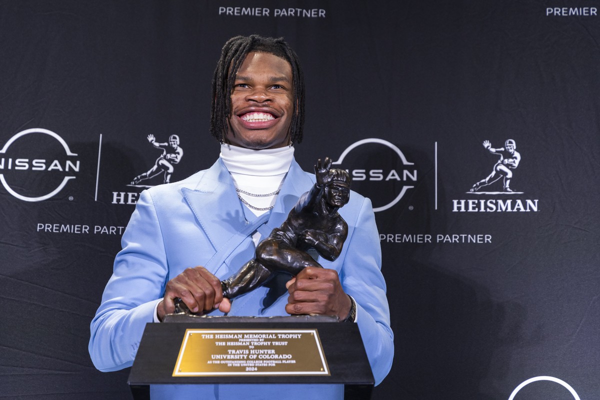 Heisman Trophy winner Travis Hunter, of Colorado, poses with the trophy at a press conference after the awards ceremony, Saturday, Dec. 14, 2024, in New York, (AP Photo/Corey Sipkin)