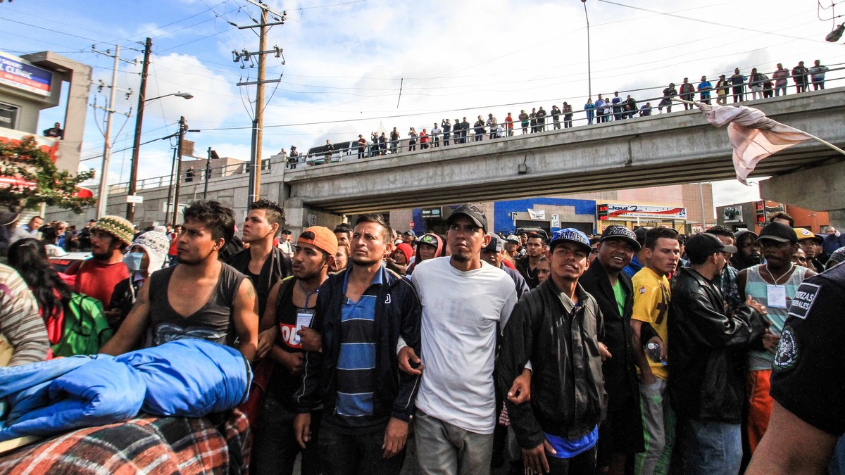 epa07183664 Central American migrants march from the shelter they occupy in Colonia Zona Norte of to the El Chaparral pedestrian gate in Tijuana, Mexico, 22 November 2018. Central American migrant car ...
