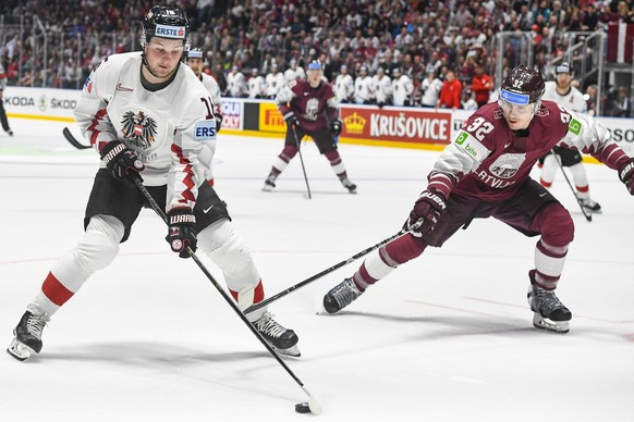 epa07562542 Dominic Zwerger of Austria (L) in action against Arturs Kulda of Latvia (R) during the IIHF World Championship group B ice hockey match between Latvia and Austria at the Ondrej Nepela Aren ...