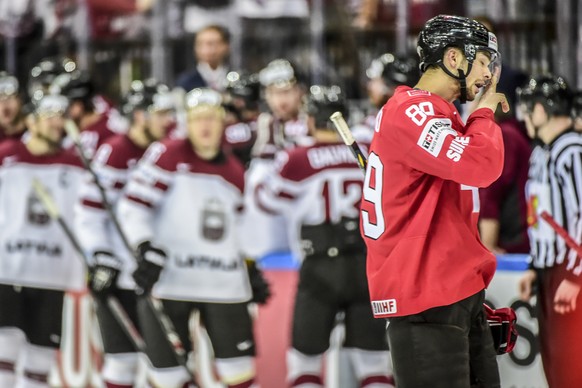 06.05.2015; Prague; Eishockey WM 2015 - IIHF ICE HOCKEY WORLD CHAMPIONSHIP;
Switzerland - Latvia;
Cody Almond (SUI) reinigt das Visier, die Letten jubeln im Hintergrund nach dem Tor zum 0:1 
(Andy Mue ...