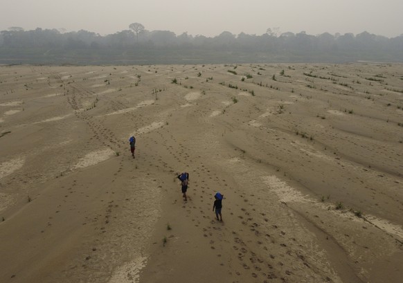 Residents transport drinking water from Humaita to the Paraizinho community, along the dry Madeira River, a tributary of the Amazon River, during the dry season, Amazonas state, Brazil, Sunday, Sept.  ...