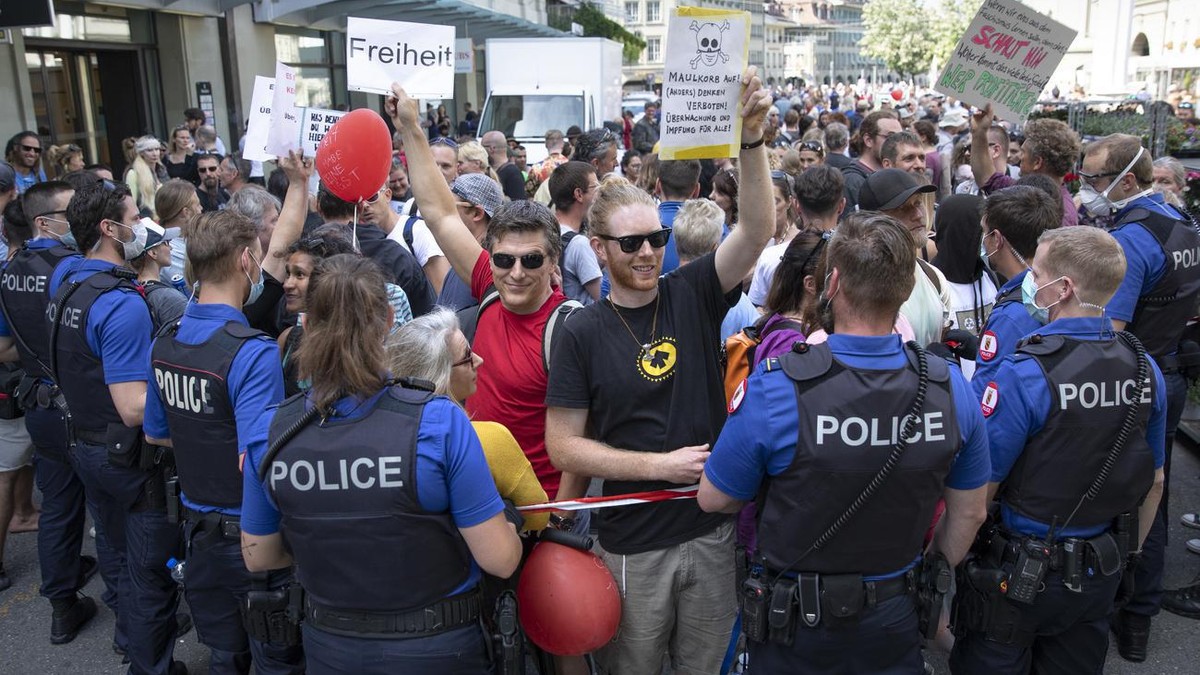 Polizisten halten Absperrbaender, um Demonstranten vom Bundesplatz fernzuhalten, bei einer Demonstration gegen den Coronavirus Lockdown, am Samstag, 9. Mai 2020 in Bern. (KEYSTONE/Peter Klaunzer)