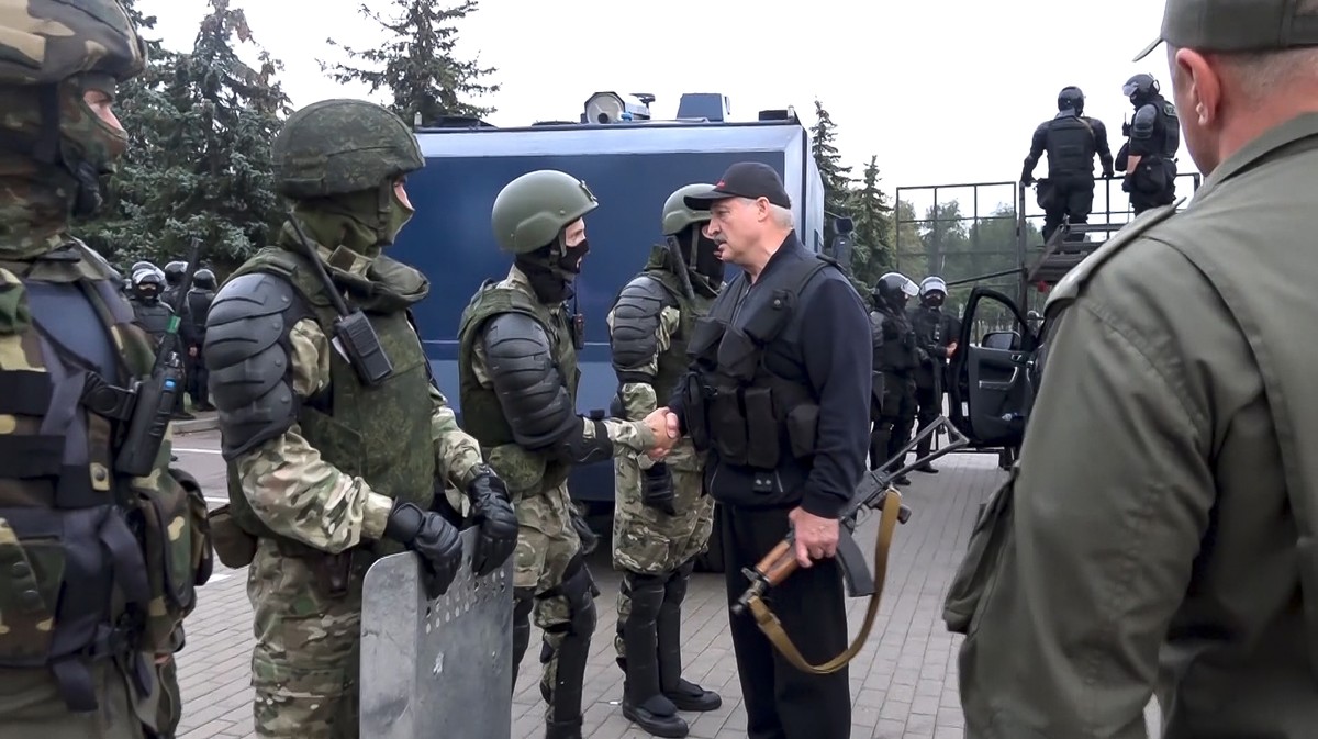 This image made from video provided by the State TV and Radio Company of Belarus, shows Belarus President Alexander Lukashenko armed with a Kalashnikov-type rifle as he thanks riot police officers nea ...