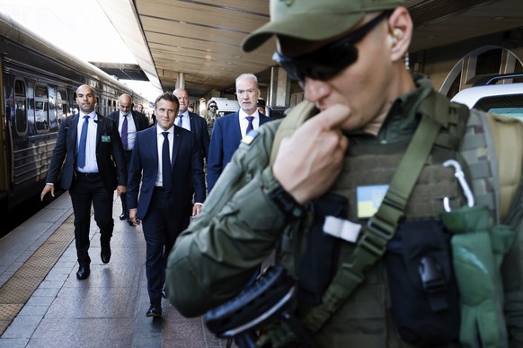 French President Emmanuel Macron, centre, is escorted as he arrives at the Kyiv train station, Thursday, June 16, 2022. French President Emmanuel Macron Prime Minister Mario Draghi and German Chancell ...