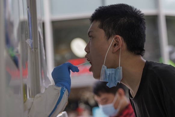 epa10066396 A man takes Coronavirus PCR test on the street, in Shanghai, China, 12 July 2022. Shanghai city reported five locally transmitted COVID-19 cases and 54 local asymptomatic infections, accor ...