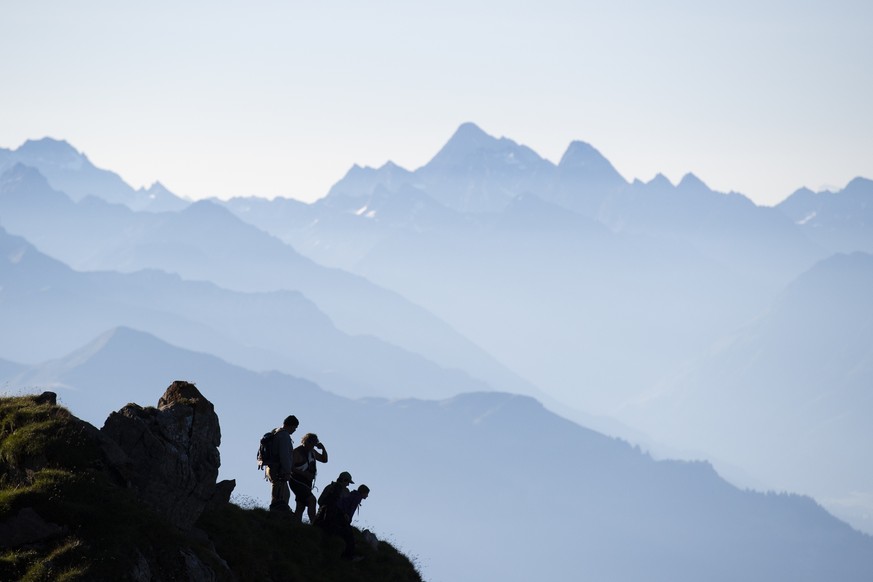 Wanderer beobachten, wie 1300 Schafe von einer Weide zur anderen wandern, am Freitag, 7. August 2020, beim &quot;Schafuebergang&quot; unter dem Gipfel des Falknis (2562 Meter) zwischen dem Guschasatte ...