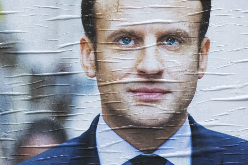 A poster for independent centrist presidential candidate Emmanuel Macron is displayed in Paris, France, Monday, April 17, 2017. French centrist candidate Emmanuel Macron and far-right leader Marine Le ...
