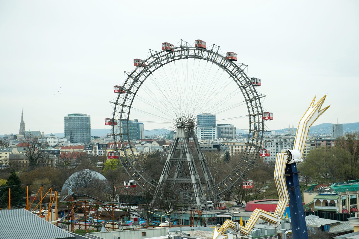 epa05239671 Vienna Giant Wheel is seen with the Stephansdom in the backround at Vienna's Prater in Vienna, Austria, on 30 March 2016. The Prater is one of the world's oldest amusement parks  ...