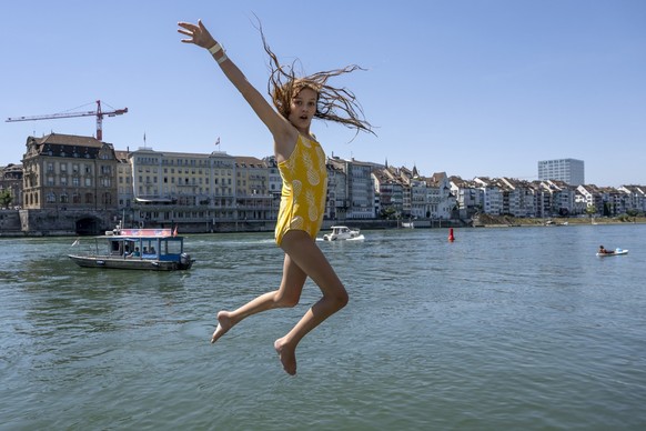 Linnea springt fuer eine Abkuehlung in den Rhein in Basel, am Montag, 18. Juli 2022. Der Bund erhoeht die Hitze-Gefahrenstufe: Ab sofort gilt die Stufe 3 von 4 fuer fast die ganze Schweiz. (KEYSTONE/G ...