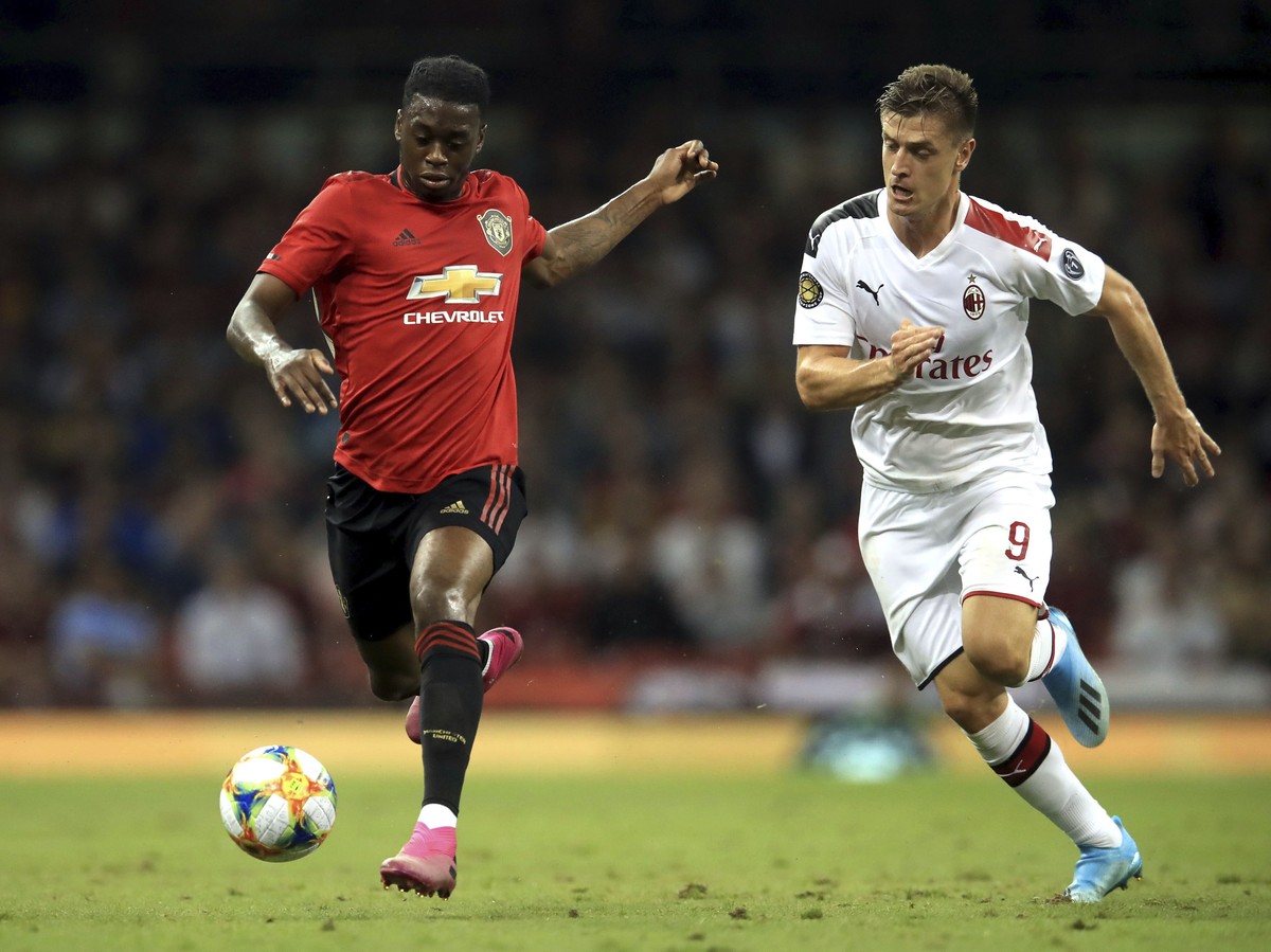 Manchester United's Aaron Wan-Bissaka, left, and AC Milan's Krzysztof Piatek battle for the ball during the Pre-Season match between Manchester United and AC Milan at the Principality Stadiu ...