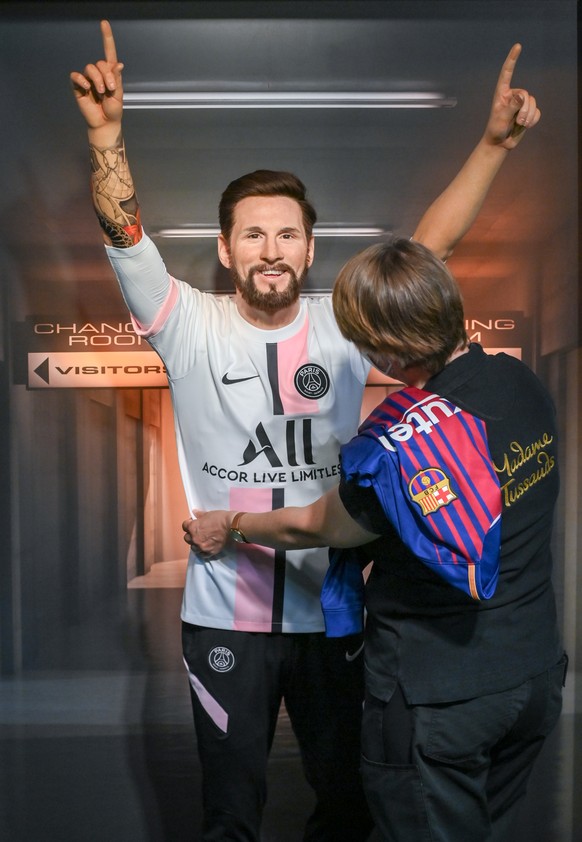 11.08.2021, Berlin: Karen Fries vom Portrait-Team zieht der Wachsfigur von Fußballer Lionel Messi bei Madame Tussauds Berlin das Trikot von Paris Saint-Germain an. Der Spieler wechselt in der nächsten ...