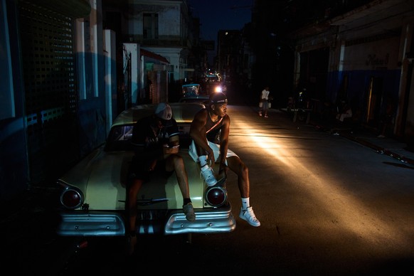 KEYPIX - Men sit on the trunk of a car during a blackout in Havana, Cuba, Tuesday, July 14, 2026. (AP Photo/Ramon Espinosa)