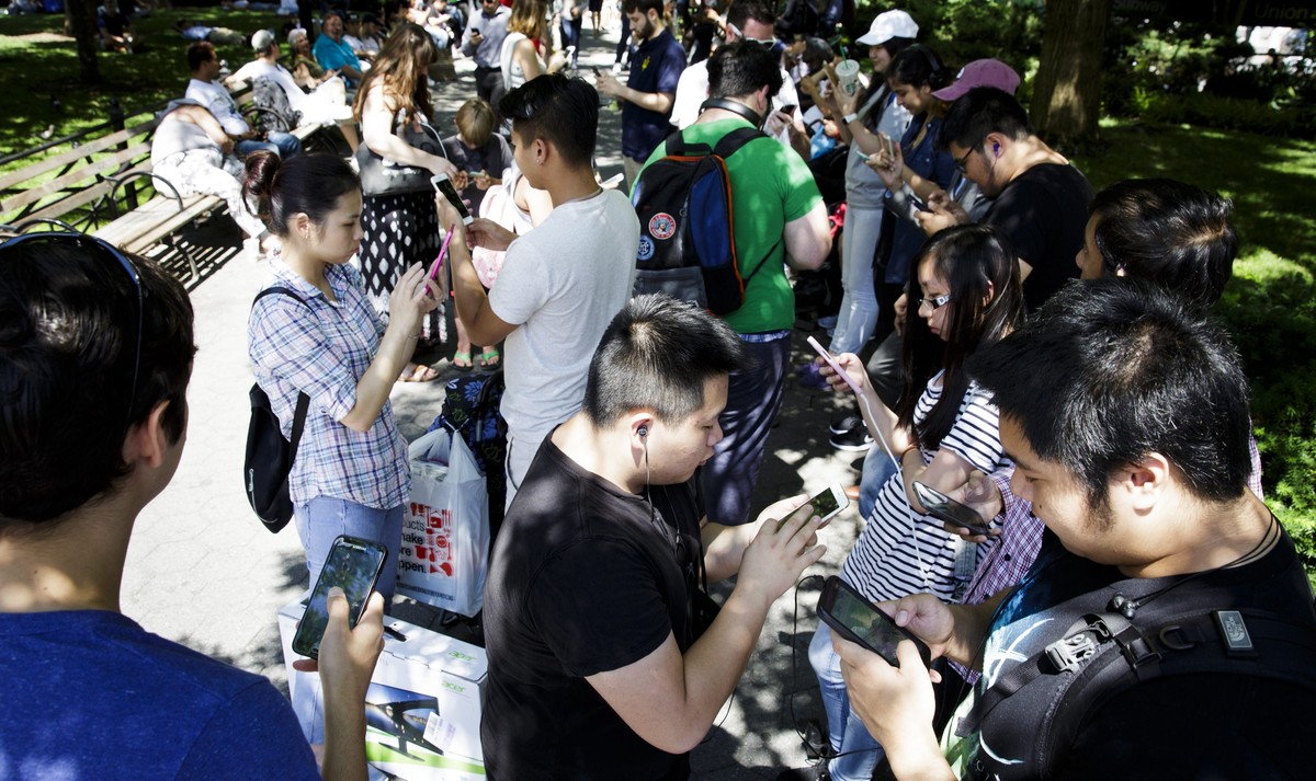 epa05421035 A group of people play the new game 'Pokémon Go' on their smartphones in Union Square in New York, New York, USA, 11 July 2016. The new game was released 08 July and has players  ...