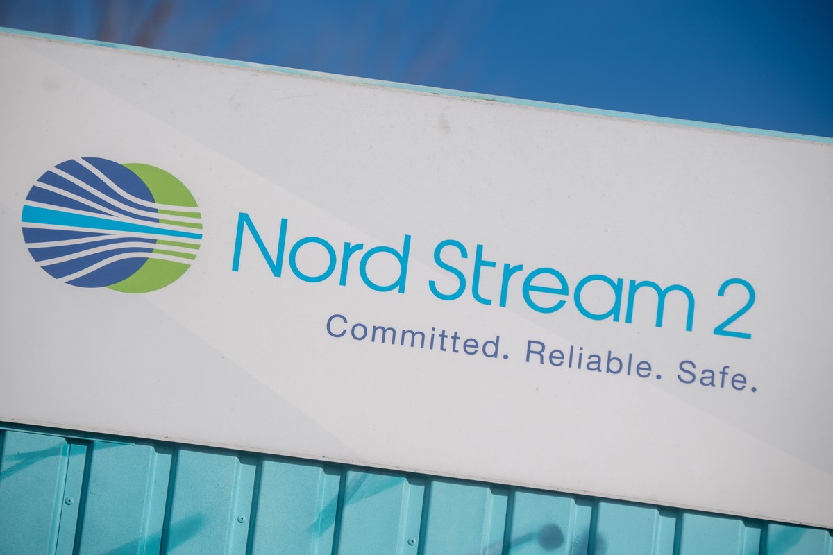 22.02.2022, Mecklenburg-Vorpommern, Lubmin: Ein Schild mit der Aufschrift �Nord Stream 2 Committed. Reliable. Safe.� h�ngt im Gewerbegebiet Lubmin �ber einer aufgemalten Landkarte an einem Infopunkt z ...