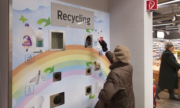 A woman disposes of a plastic bottle at the recycling station of a Coop retail store in Leimbach, in the Canton of Zurich, Switzerland, on Febraury 12, 2015. (KEYSTONE/Gaetan Bally)

Eine Frau entsorg ...