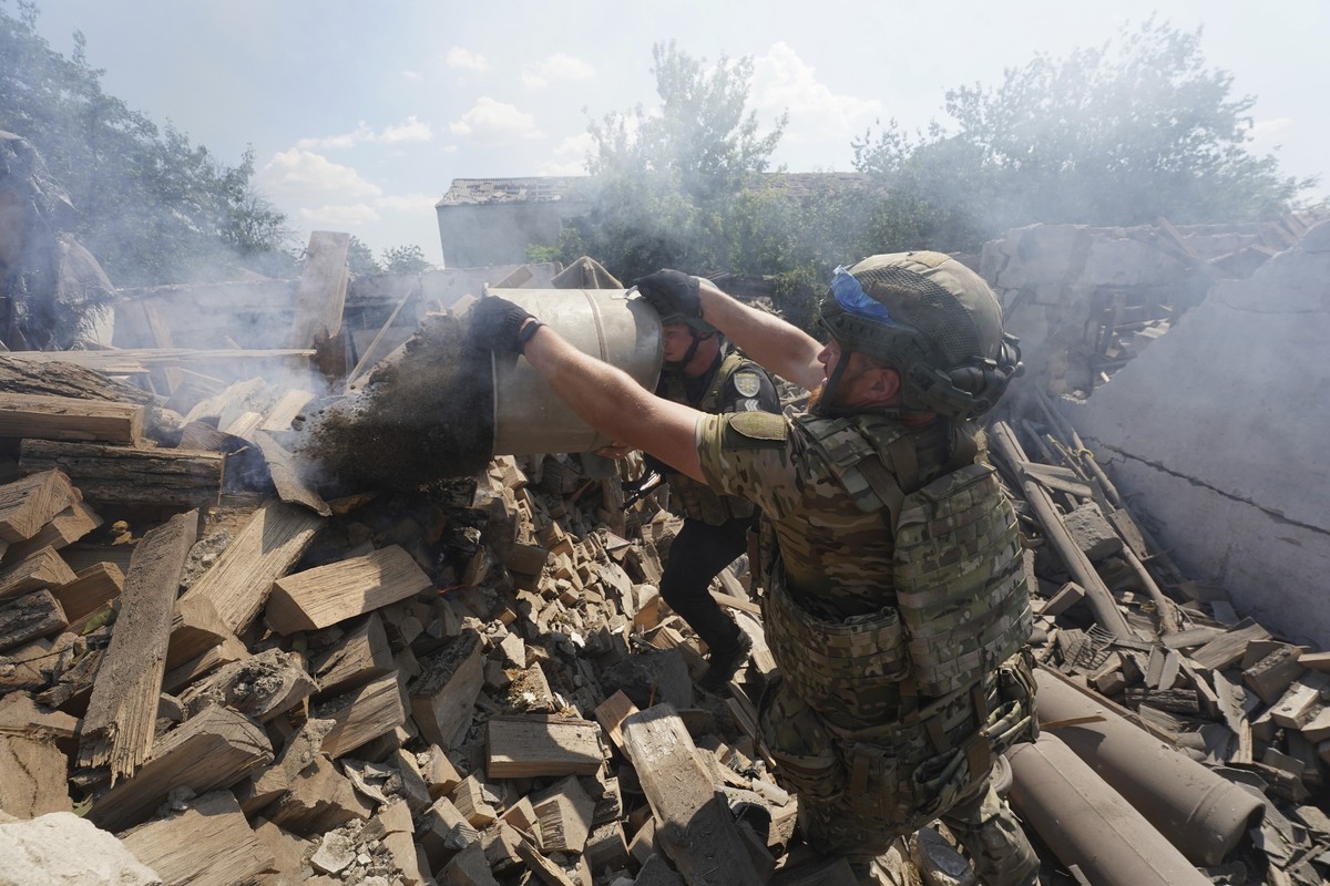 Police officers extinguish a fire after Russian airstrike on residential neighbourhood of Bilyi Kolodiaz, Kharkiv region, Ukraine, Thursday, July 11, 2024. (AP Photo/Andrii Marienko)