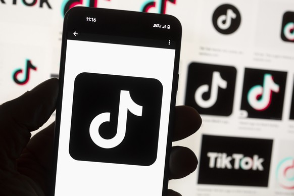 FILE - The TikTok logo is seen on a cell phone on Oct. 14, 2022, in Boston. North Dakota Gov. Doug Burgum has banned the popular social media app TikTok from devices owned by the state government's ex ...