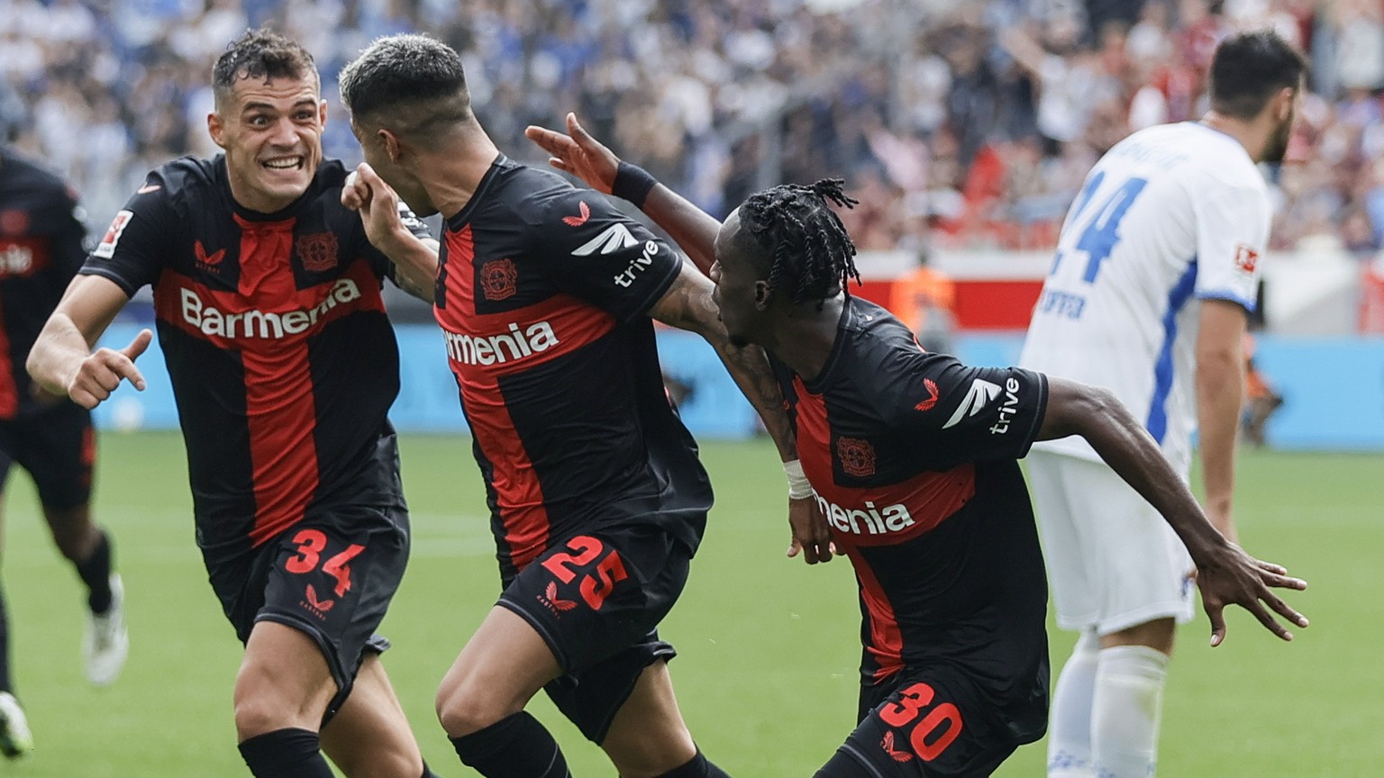 epa10835904 Leverkusen&#039;s Exequiel Palacios (C) celebrates with Granit Xhaka (L) and Jeremie Frimpong after scoring the 2-1 lead during the German Bundesliga soccer match between Bayer Leverkusen  ...