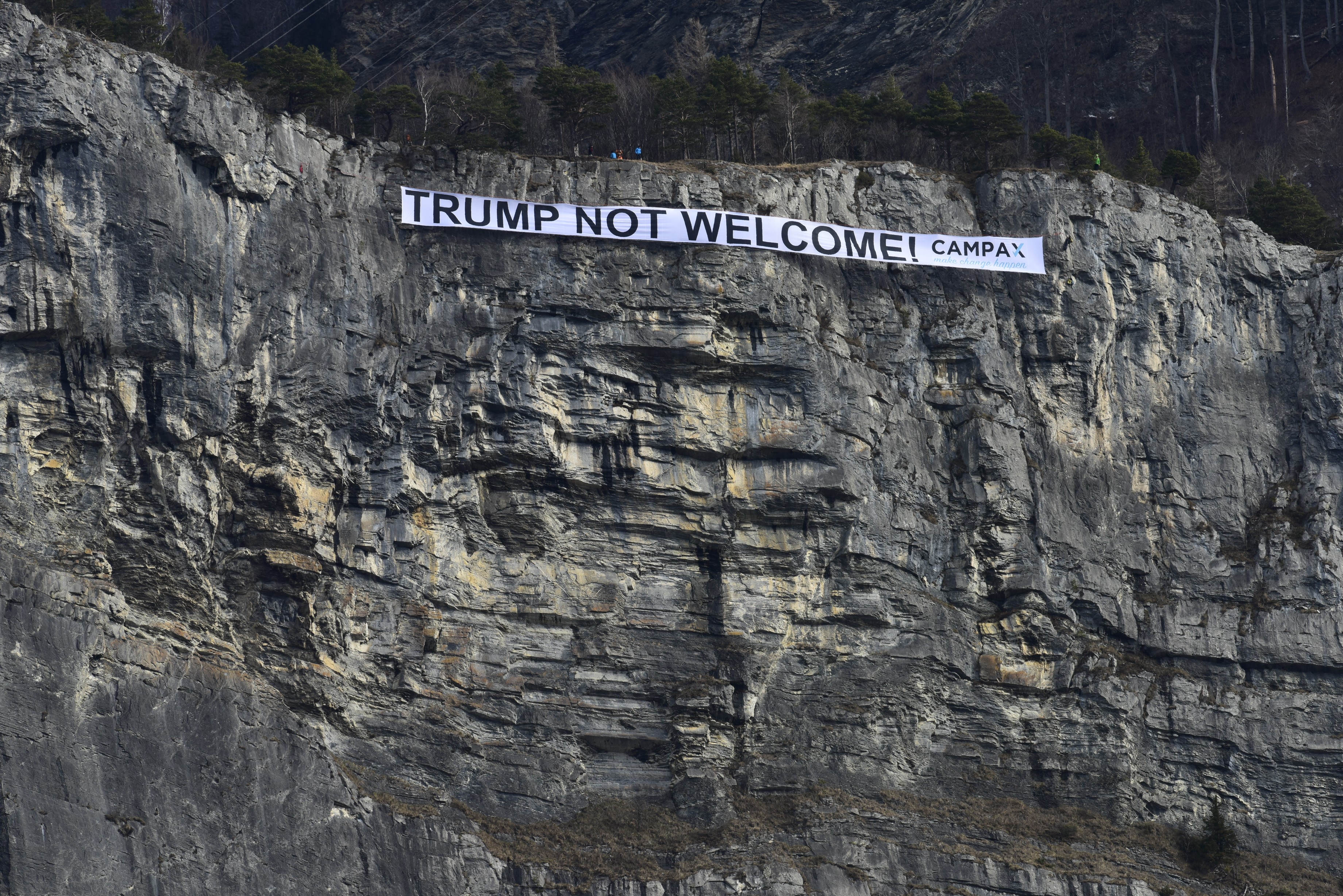 HANDOUT - A banner with the inscription "Trump not welcome!" is hanging in a rock face of the Ellhorn mountain near Sargans, Switzerland, on Thursday, January 25, 2018. The campaign organisa ...