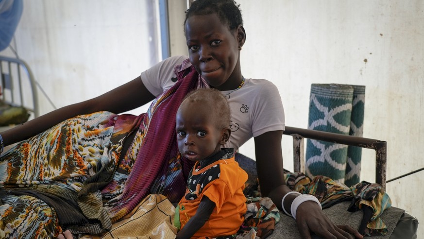 FILE - A mother sits with her malnourished baby at a hospital run by Medicines Sans Frontieres (Doctors Without Borders) in Old Fangak in Jonglei state, South Sudan on Dec. 28, 2021. A new report rele ...
