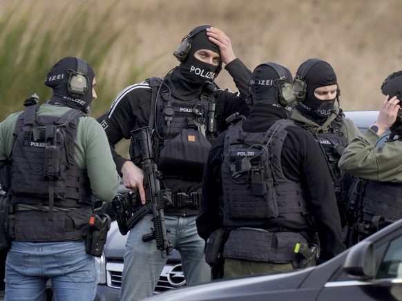 Police officers prepare for an operation close to a road where two police officers were shot during a traffic stop near Kusel, Germany, Monday, Jan. 31, 2022. Police say two officers have been shot de ...