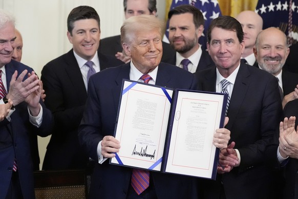 President Donald Trump, center, surrounded by House Majority Whip Tom Emmer, R-Minn., from left, Rep. Bryan Steil, R-Wis., Vice President JD Vance, Sen. Bill Hagerty, R-Tenn., and Commerce Secretary H ...