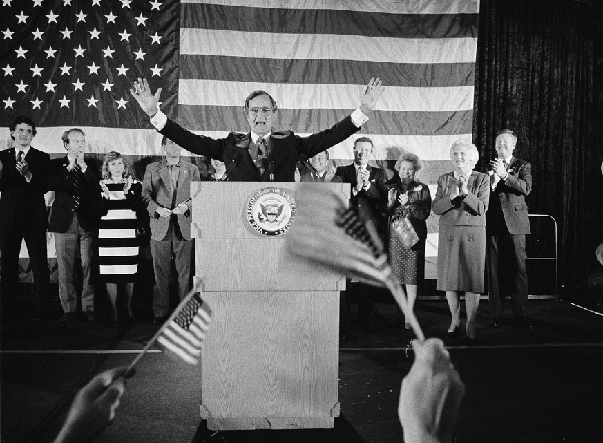 FILE - In this Nov. 7, 1984 file photo, flag-wavers greet Vice President George Bush after he was re-elected to the post of vice president, in Houston, Texas. The vice president&#039;s wife Barbara Bu ...