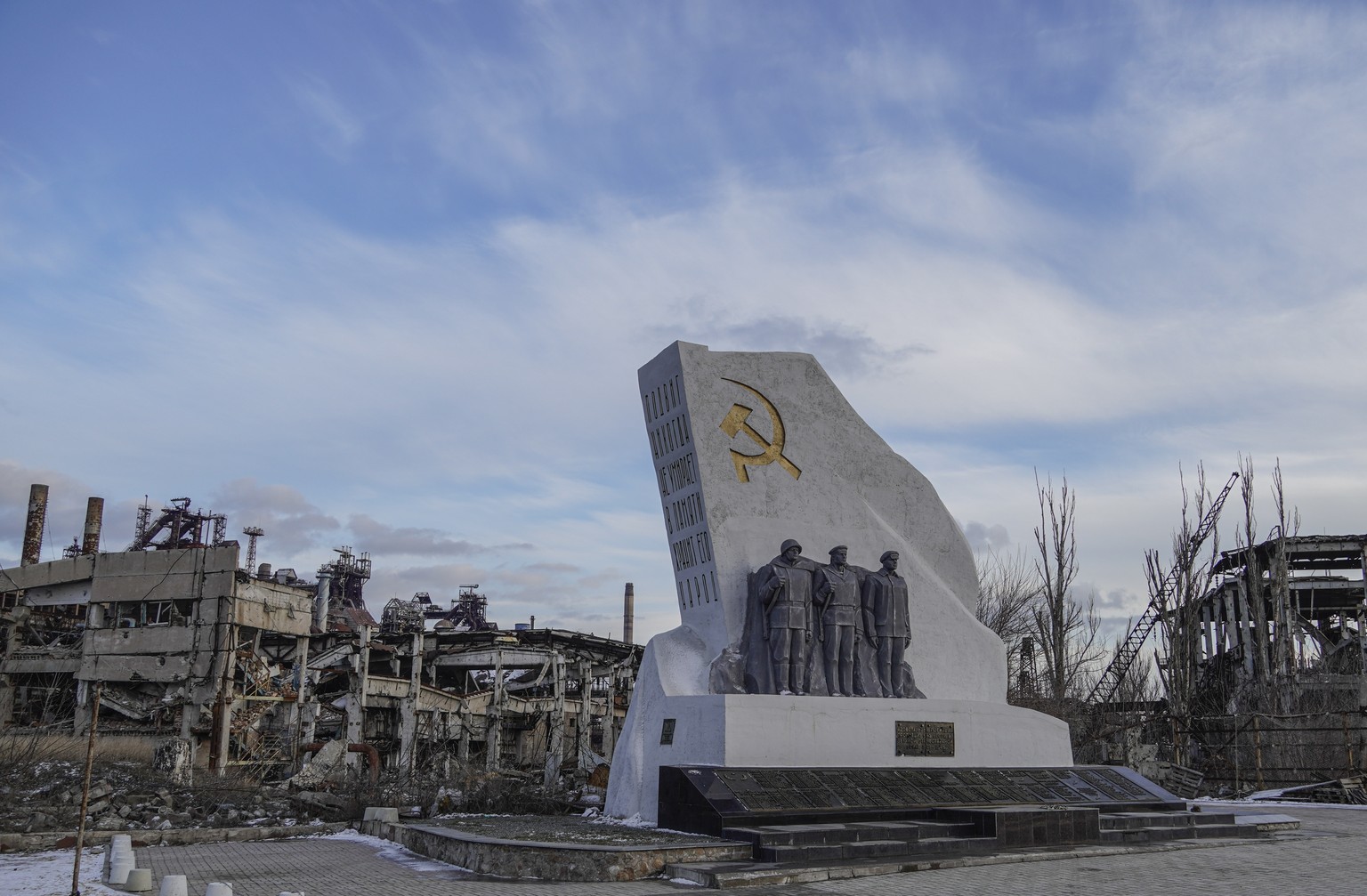epa11912672 A restored monument with the inscription: ?The feat never dies, the people keep it in memory? seen through the demolished Azovstal steel plant in Mariupol, Donetsk region, 16 February 2025 ...