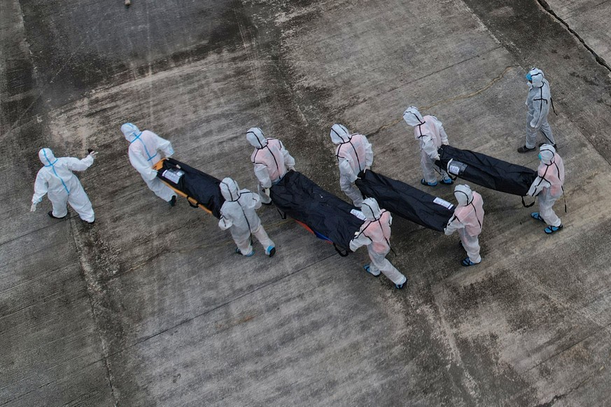 Rescuers carry the remains of victims of the recent fire on the MV June Aster ferry as they arrive on board a Philippine Coast Guard vessel at the Borac port in Coron, Palawan province, western Philip ...