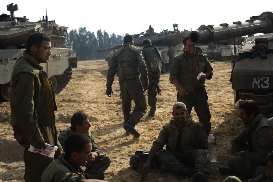 epa04338532 Israeli soldiers sit next to their tanks, during a break from the Gaza offensive, at an unspecified location next to the Israeli Gaza Strip border, 02 August 2014. A 72-hour ceasefire betw ...