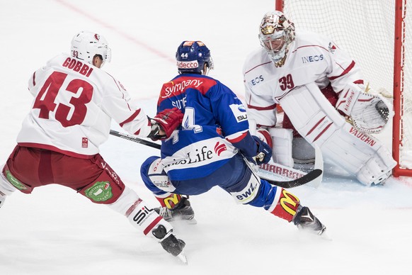 Der Zuercher Pius Suter, Mitte, spielt um den Puck Goalie Cristobal HuetÃ, rechts, von Lausanne beim Eishockeyspiel der National League ZSC Lions gegen dem Lausanne HC im Hallenstadion in Zuerich, au ...