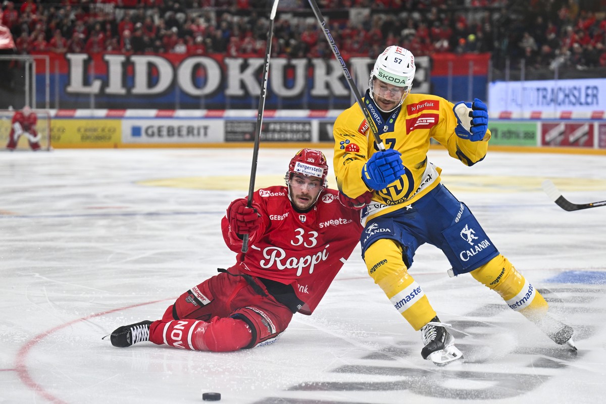 Valentin Hofer (SCRJ), links, gegen Davyd Barandun (HCD) im Eishockeyspiel der National League zwischen den Rapperswil-Jona Lakers und dem HC Davos, am Samstag, 1. Maerz 2025, in der St. Galler Kanton ...