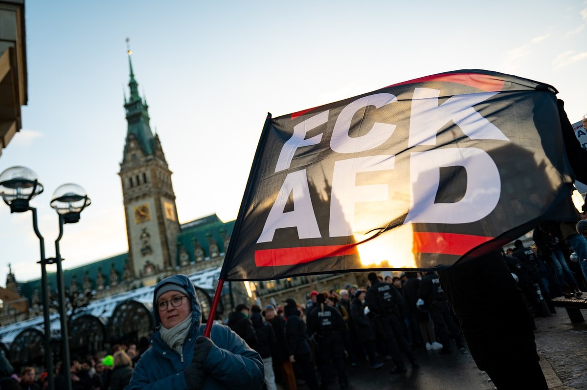 19.01.2024, Hamburg: «FCK AFD» steht auf einer Fahne vor dem Rathaus. Mit der Demonstration wollen die Teilnehmenden ein Zeichen des Widerstands gegen rechtsextreme Umtriebe setzen. Foto: Jonas Walzbe ...