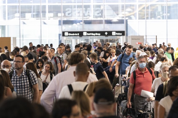 Menschen warten am Flughafen auf ihren Abflug in die Ferien, aufgenommen am Samstag, 16. Juli 2022 auf dem Flughafen in Zuerich. (KEYSTONE/Ennio Leanza)