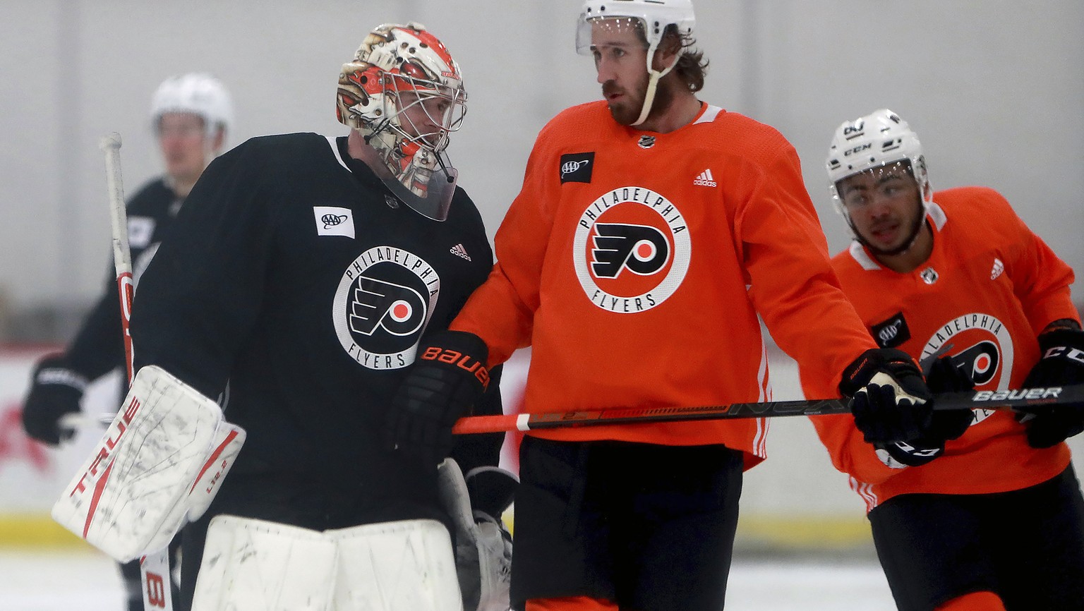 CORRECTS PERSON AT RIGHT TO KEVIN HAYES AND NOT JAKUB VORACEK AS ORIGINALLY SENT - Philadelphia Flyers goalie Carter Hart, left, and Kevin Hayes talk during an NHL hockey practice in Voorhees, N.J., T ...