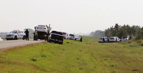 Police and investigators are seen at the side of the road outside Rosthern, Saskatchewan on Wednesday, Sept. 7, 2022. Canadian police arrested the second suspect in the stabbing deaths of 10 people in ...