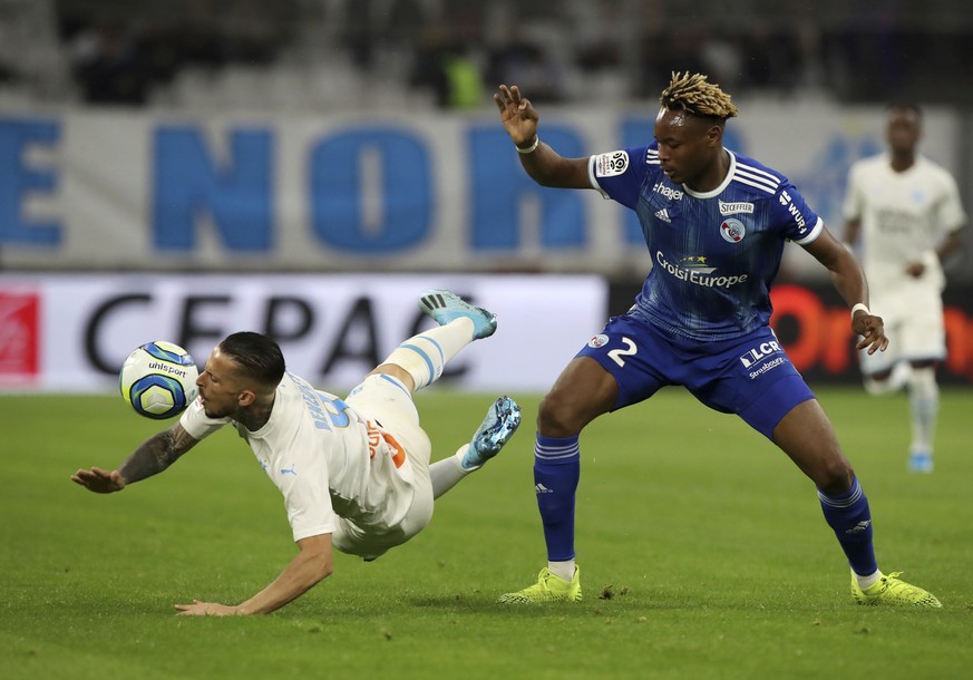 Marseille&#039;s Dario Benedetto, left, duels for the ball with Strasbourg&#039;s Mohamed Simakan during the French League One soccer match between Marseille and Strasbourg at the Velodrome stadium in ...