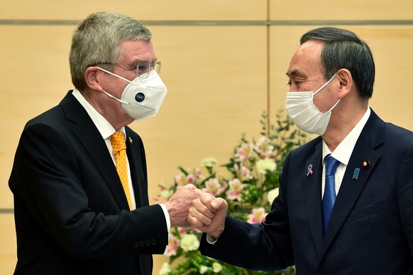 epa08823278 Japan&#039;s Prime Minister Yoshihide Suga (R) greets International Olympic Committee (IOC) president Thomas Bach (L) during their meeting in Tokyo, Japan, 16 November 2020. EPA/KAZUHIRO N ...