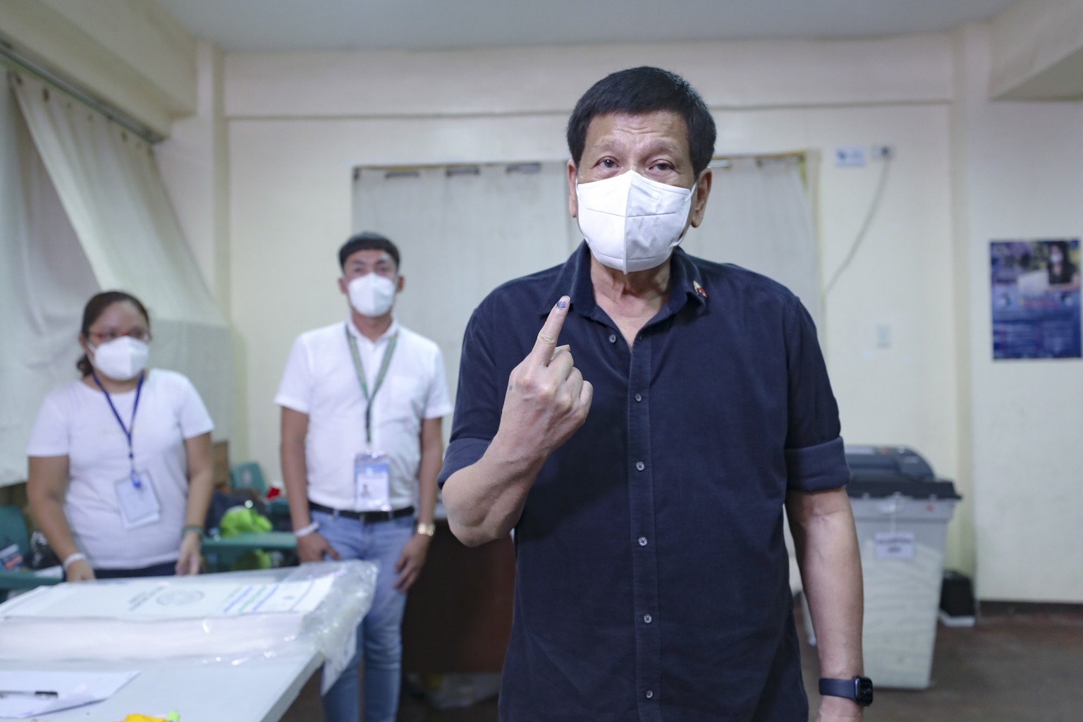 epa09935613 A handout photo made available by the Presidential Photographers Division (PPD) shows Philippine President Rodrigo Duterte showing his ink-stained finger after casting his ballot for the 2 ...