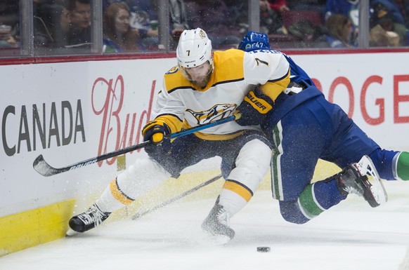 Nashville Predators defenseman Yannick Weber (7) fights for control of the puck with Vancouver Canucks&#039; Sven Baertschi during the third period of an NHL hockey game Tuesday, Nov. 12, 2019, in Van ...