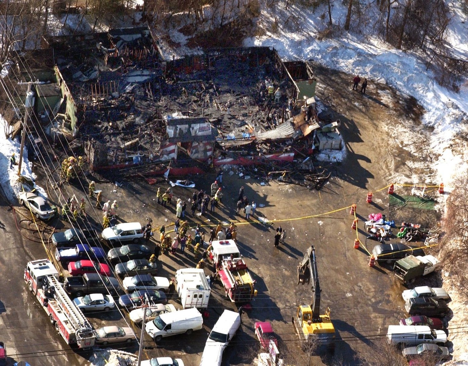 From the air the burned out remains of The Station nightclub where atleast 60 people died in a late night fire on Thursday, Feb. 20, 2003 in West Warwick, R.I., is seen in the center top, Friday, Febr ...
