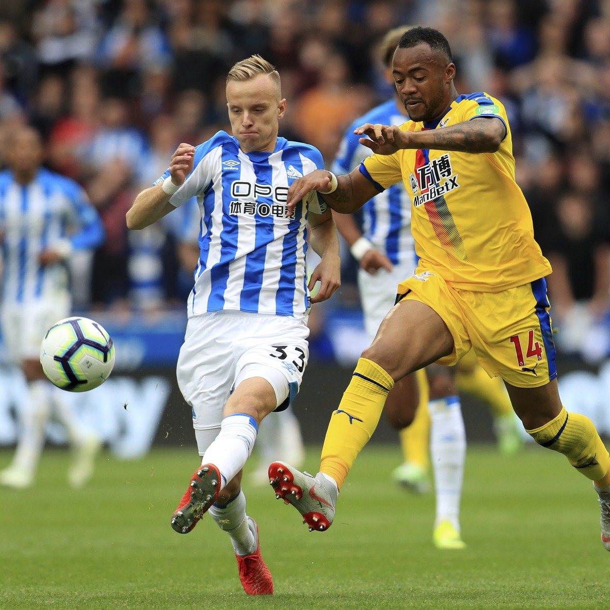 Huddersfield's Florent Hadergjonaj, left and Crystal Palace's Jordan Ayew battle for the ball during the English Premier League soccer match between Huddersfield Town and Crystal Palace, at  ...