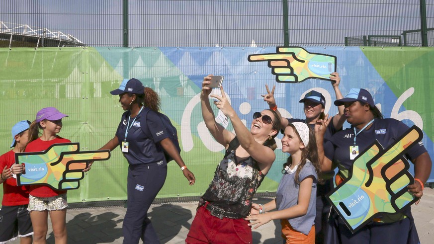 2016 Rio Olympics - Olympic Park - Rio de Janeiro, Brazil - 07/08/2016. Olympic volunteers pose for pictures with spectators outside Olympic Park. REUTERS/Reinhard Krause TPX IMAGES OF THE DAY