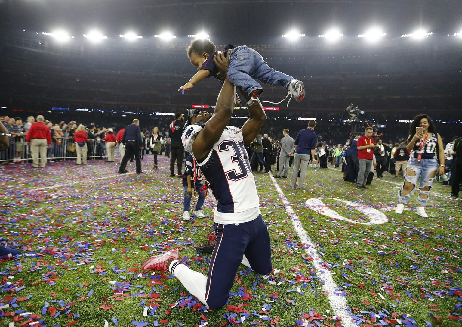 epa05774248 New England Patriots free safety Duron Harmon (L) plays with a child on the field after the New England Patriots defeated the Atlanta Falcons in Super Bowl LI at NRG Stadium in Houston, Te ...