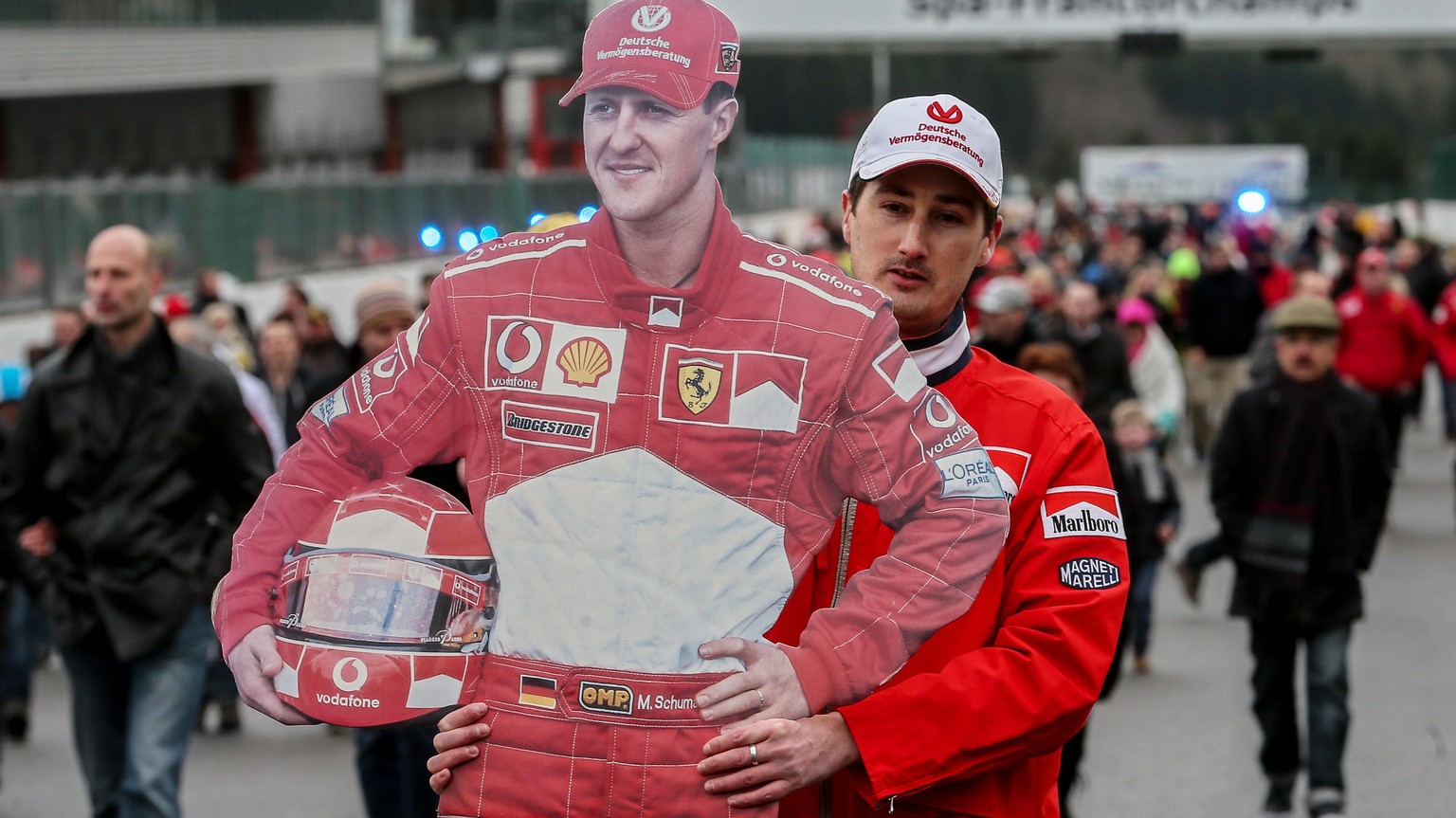 epa04042757 A fan of German Formula One legend Michael Schumacher carries a life-size cardbord cutout of his idol on the Spa Fancorchamp racetrack, Belgium, 26 January 2014. Thousands of fans coming f ...