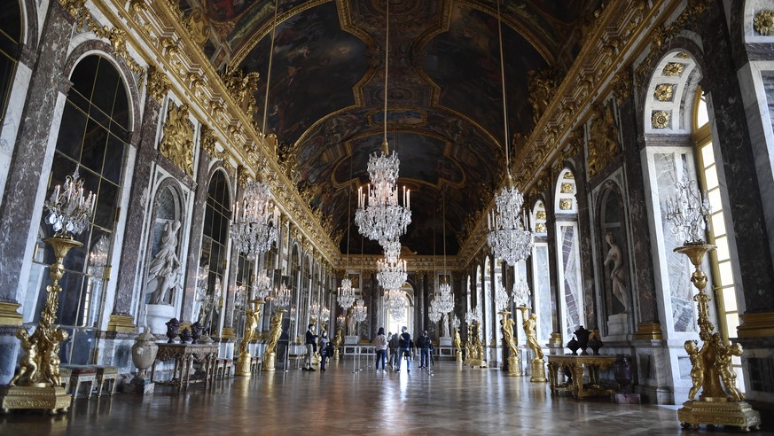 epa08468875 Visitors wearing protective face masks in the Galerie des Glaces (Hall of Mirrors) during the reopening day of the Chateau de Versailles in Versailles, near Paris, France, 06 June 2020. Af ...