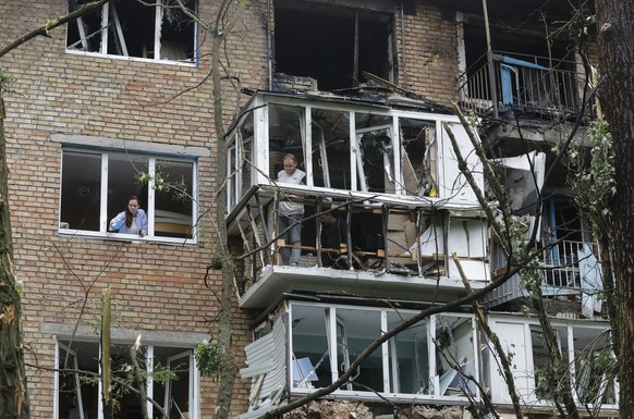 epa12129846 Residents clear debris at the site of a nine-storey residential building struck by a drone in Kyiv, Ukraine, 24 May 2025, amid the ongoing Russian invasion. Nobody was killed, but at least ...