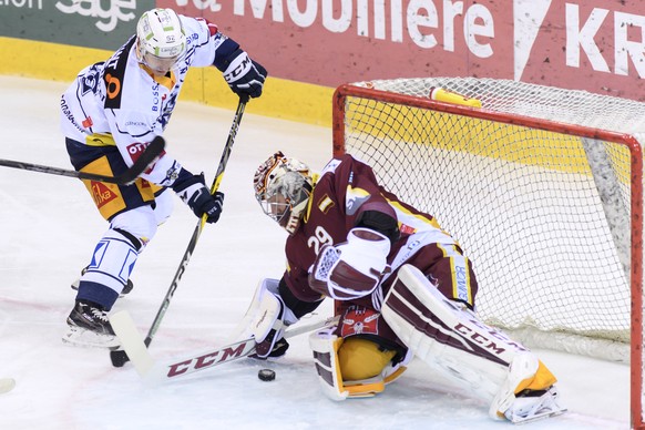 Le joueur zougois, Jarkko Immonen, gauche, a la lutte pour le puck avec le gardien Genevois, Robert Mayer, droite, lors du match du championnat suisse de hockey sur glace de National League LNA, entre ...